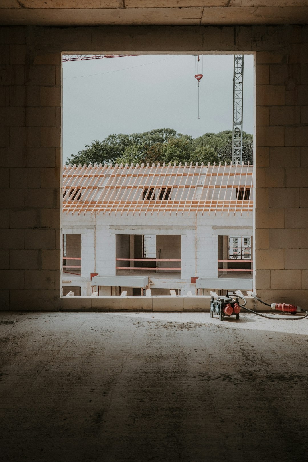 Construction site viewed from inside an unfinished concrete building.
